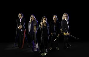 Die Band Foreigner vor einem dunklen Hintergrund als Gruppenfoto