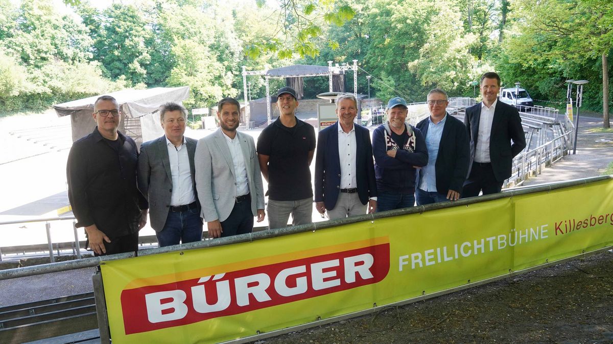Acht Männer stehen an der Freilichtbühne hinter einem grünen Banner der Firma Bürger: von links nach rechts: Paul Woog von SKS Michael Russ, Viktor Schoner als Intendant der Staatsoper Stuttgart, Christian Eisenhadt Abteilungsleiter der in.Stuttgart, Arnulf Woock als Pressesprecher des Music Circus Concertbüro, Andreas Kroll als Geschäftsführer der in.Stuttgart, Marc Oßwald als Geschäftsführer von Vaddi Concerts, Christian Doll als Geschäftsführer von C2 Concerts und Martin Bihlmaier als Geschäftsführer von der Firma BÜRGER