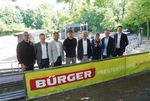 Acht Männer stehen an der Freilichtbühne hinter einem grünen Banner der Firma Bürger: von links nach rechts: Paul Woog von SKS Michael Russ, Viktor Schoner als Intendant der Staatsoper Stuttgart, Christian Eisenhadt Abteilungsleiter der in.Stuttgart, Arnulf Woock als Pressesprecher des Music Circus Concertbüro, Andreas Kroll als Geschäftsführer der in.Stuttgart, Marc Oßwald als Geschäftsführer von Vaddi Concerts, Christian Doll als Geschäftsführer von C2 Concerts und Martin Bihlmaier als Geschäftsführer von der Firma BÜRGER