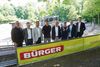 Die Veranstalter der BÜRGER Freilichtbühne 2025 aufgestellt vor einem Banner der Firma BÜRGER. v.l.n.r.: Paul Woog (Geschäftsführer SKS Michael Russ), Viktor Schoner (Intendant Staatsoper Stuttgart), Christian Eisenhardt (Abteilungsleiter in.Stuttgart), Arnulf Woock (Pressesprecher Music Circus Concertbüro), Andreas Kroll (Geschäftsführer in.Stuttgart), Marc Oßwald (Geschäftsführer Vaddi Concerts), Christian Doll (Geschäftsführer C2 Concerts), Martin Bihlmaier (Geschäftsführer BÜRGER)