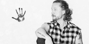 Samu Haber Promo-Bild in Schwarz-Weiß, sitzend an einer Wand mit Handabdruck mit Herz an der Wand