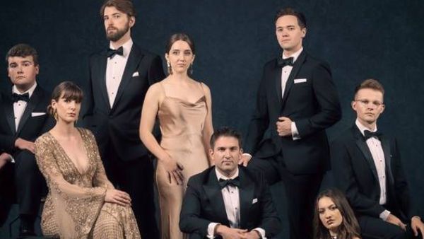 Die 8 Sängerinnen und Sänger von Voces8 im Abendkleid und Anzug