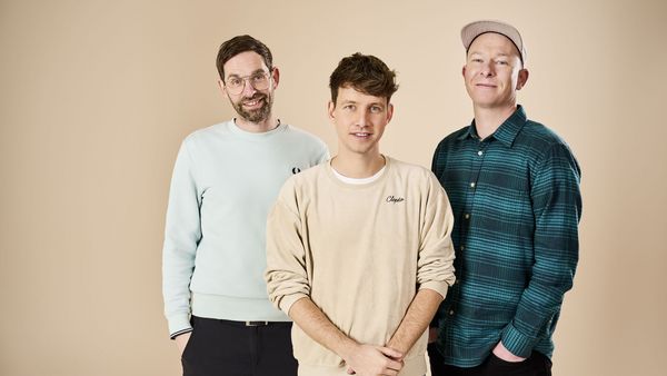 Die drei Bandmitglieder von Deine Freunde stehen nebeneinander für ein Gruppenfoto.